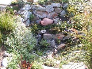 Gartengestaltung, Natursteinmauer, Gartenpflege, Amphore vor Naturstein